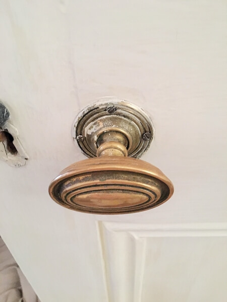 A brass doorknob on a period door in Terenure prior to being restored by Impressions painting and decorating