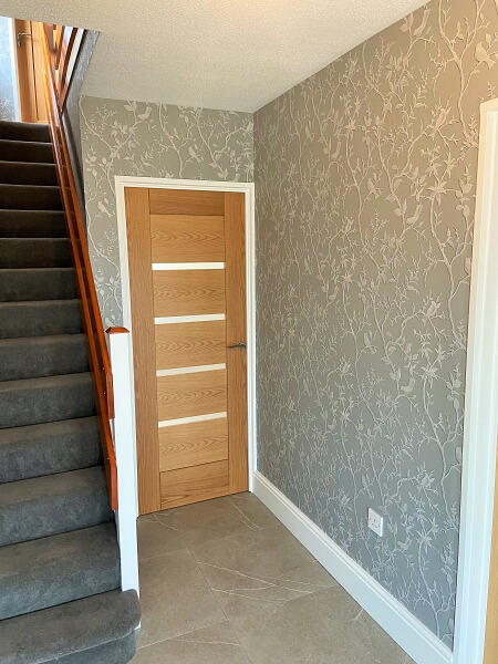 Shankill hall stairs and landing wallpapered and painted ceiling and walls and woodwork by Impressions Painting and Decorating