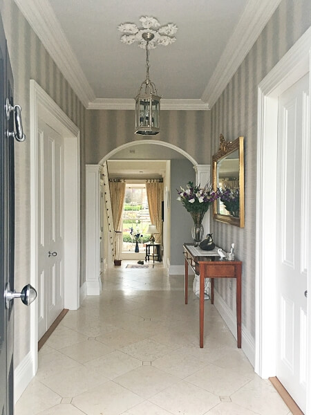 Wallpapered and decorated hallway with restored ceiling rose and cornice and ceiling in a Dalkey period home by Impressions Painters and Decorators