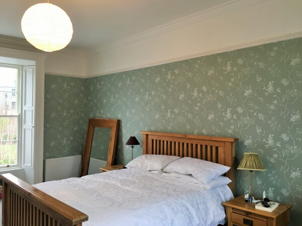 After photo of a master bedroom in a period house that was wallpapered and redecorated by Impressions Painting and Decorating Killiney